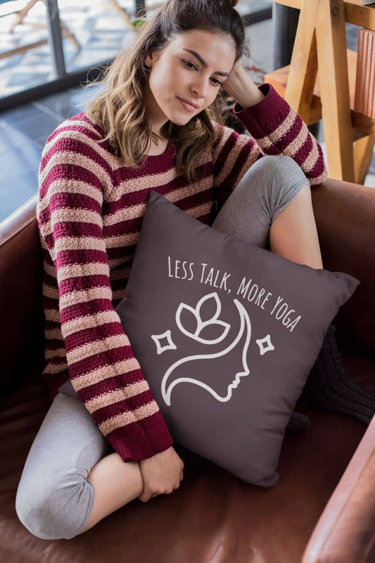 Experience Serenity with the Less Talk More Yoga Pillow with the girl hugging a pillow sitting pensively on the sofa
