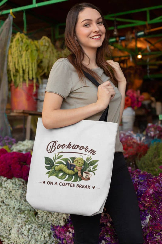 Library tote bag with a woman carrying a white canvas tote bag featuring the text 'Bookworm on a Coffee Break', standing in front of a flower shop