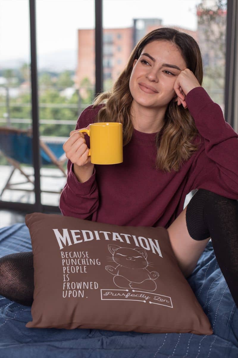 Meditation pillow with a girl sitting by the window with one hand supporting her head while the other hand is holding a cup