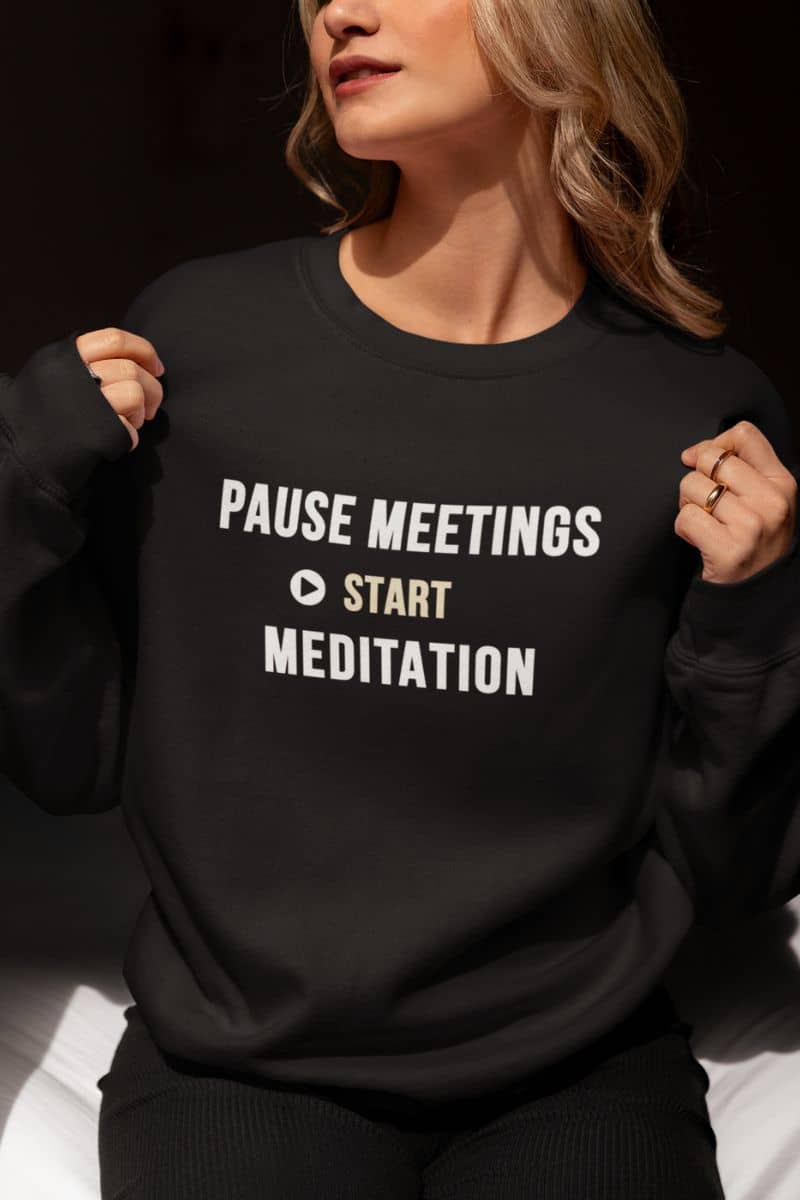 Meditation sweatshirt featuring a woman wearing a sweatshirt with text 'Pause Meetings, Start Meditation'