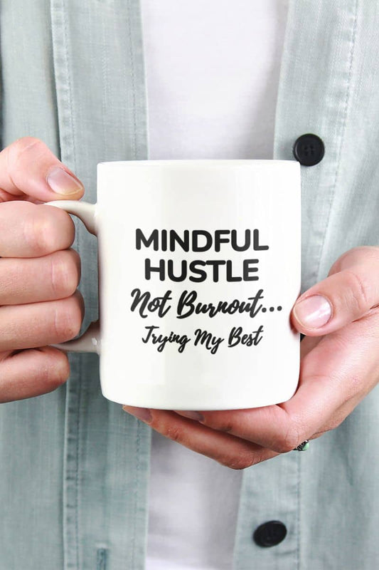 Mental health coffee mug with a person holding a mug with text 'Mindful Hustle Not Burnout... Trying My Best'.