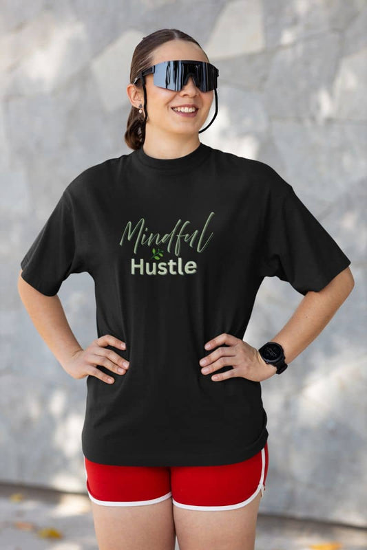 Motivational-entrepreneur-shirt with a person wearing a black t-shirt with 'Mindful Hustle' text, red shorts, and sunglasses outdoors.