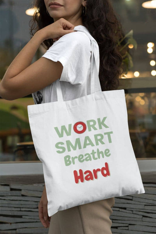 Motivational office tote bag with a person holding a tote bag with 'Work Smart Breathe Hard' text.