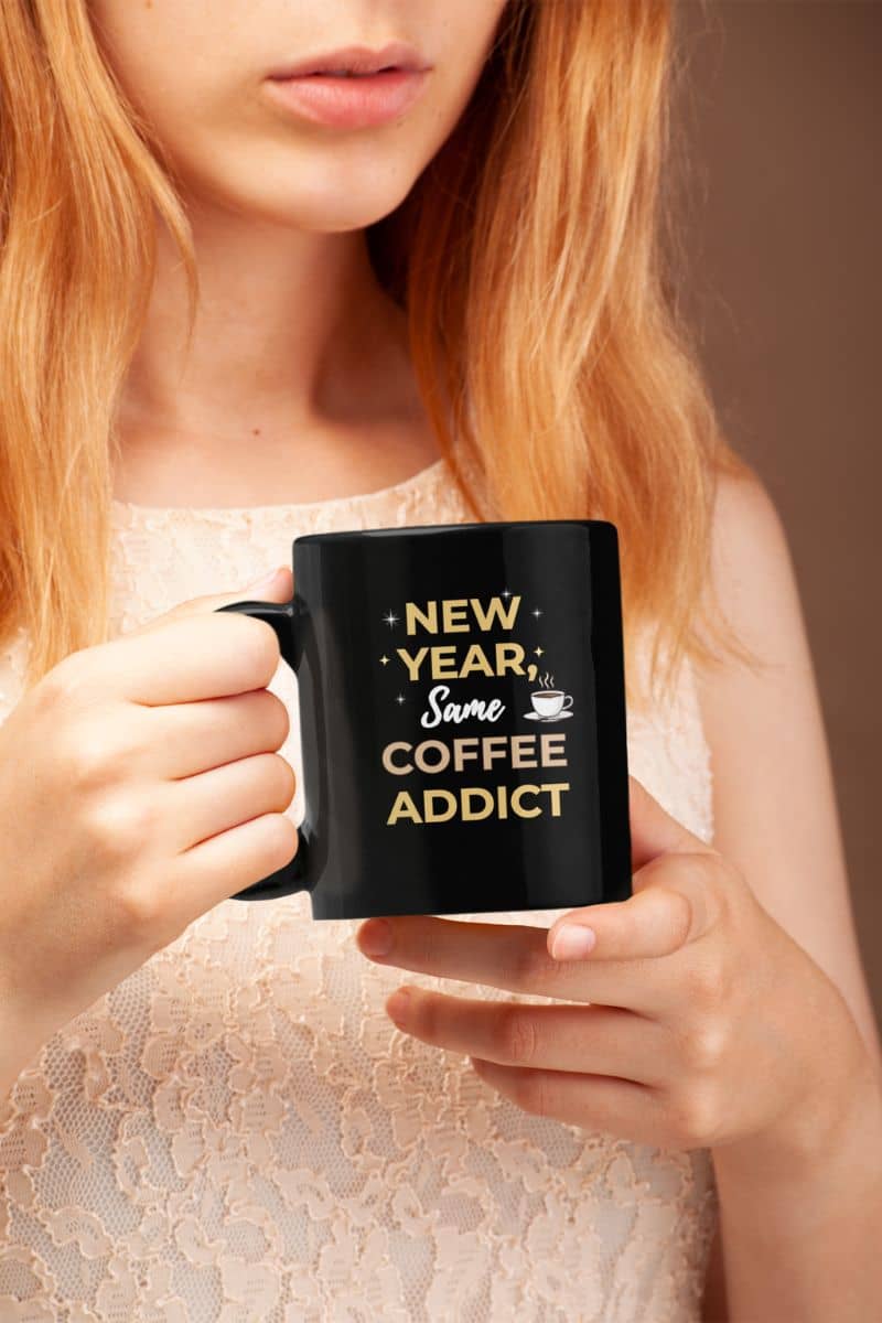Office humor mug with a person holding mug with text 'New Year, Same Coffee Addict'