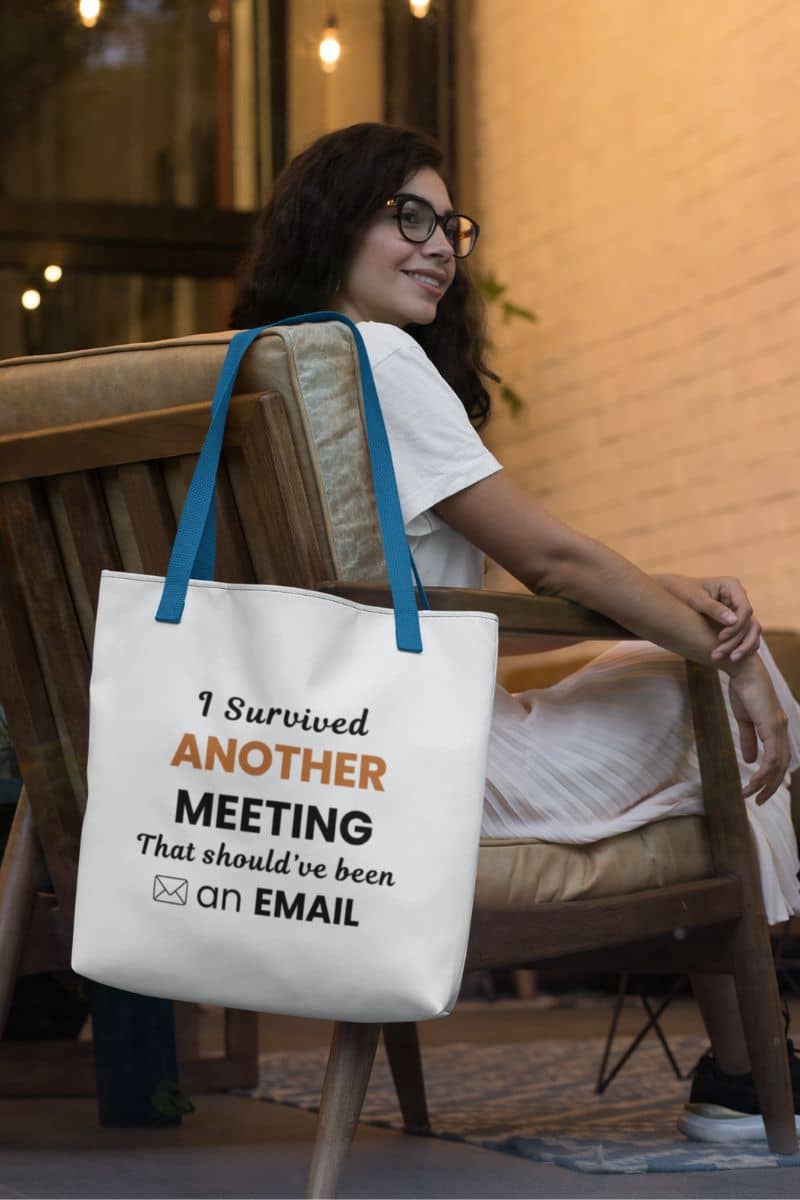Office humor tote with a person sitting on a chair holding a tote bag with text 'Office Humor Tote – I Survived Another Meeting That Should’ve Been an Email'.