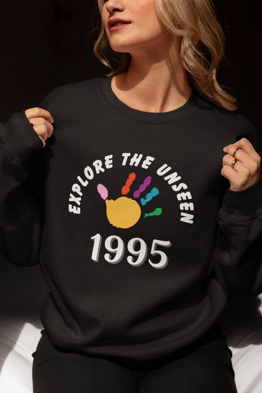 Outdoor quote sweatshirt with a person wearing a black sweatshirt with 'Explore the Unseen 1995' design.