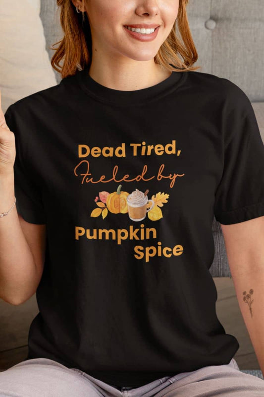 Pumpkin spice season t-shirt featuring  a person wearing a black t-shirt with text 'Dead Tired, Fueled by Pumpkin Spice'