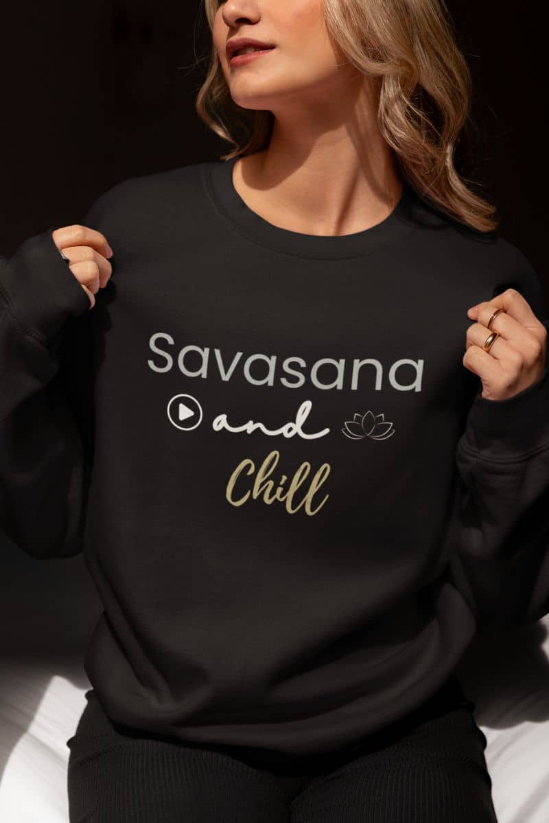 Relaxation sweatshirt for women with a person wearing a black sweatshirt with 'Savasana and Chill' text