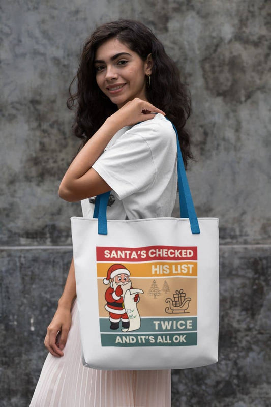 Retro christmas tote bag with a woman holding a tote bag with text 'Santa's Checked His List Twice And It's All Ok'