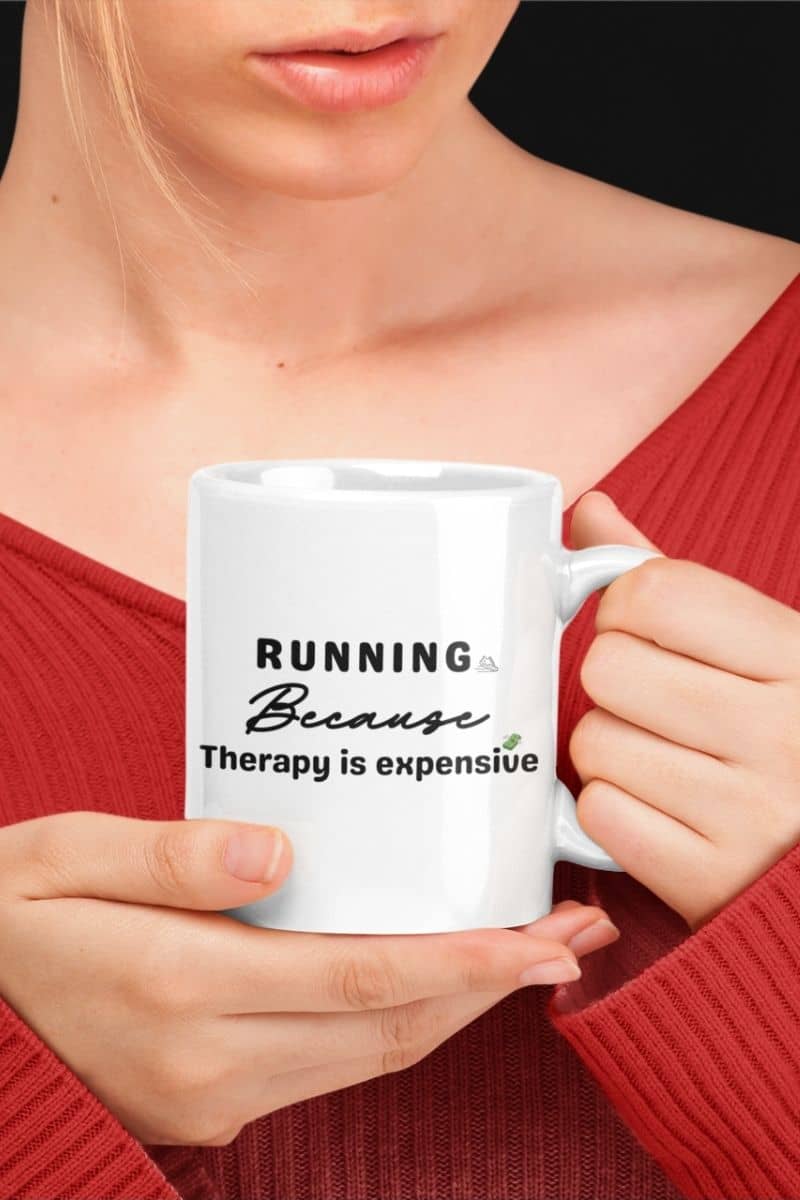 Running humor mug with a woman holding a mug with text 'Running because therapy is expensive'