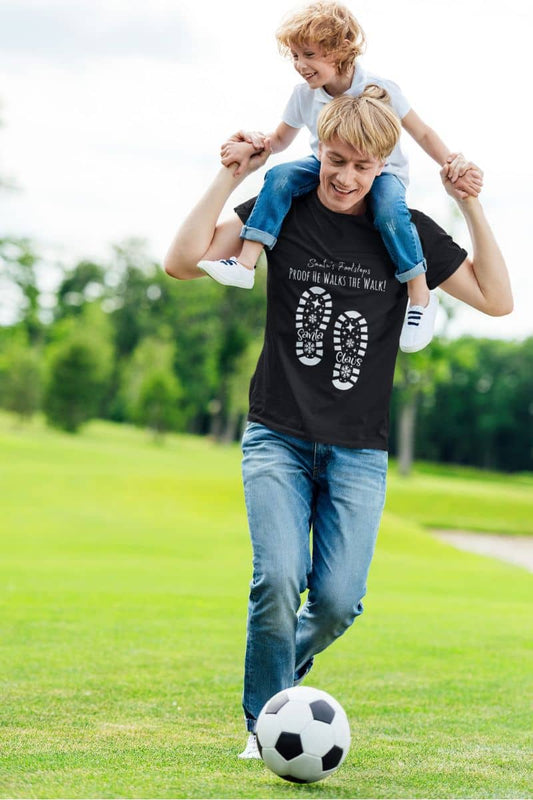 Santa's Footsteps T-Shirt with a man carrying his son on his shoulders and playing soccer happily