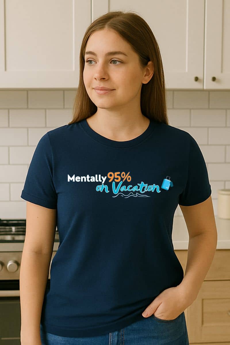 Sarcastic holiday shirt with a person wearing a navy blue t-shirt featuring the text 'Mentally 95% on Vacation' in a kitchen
