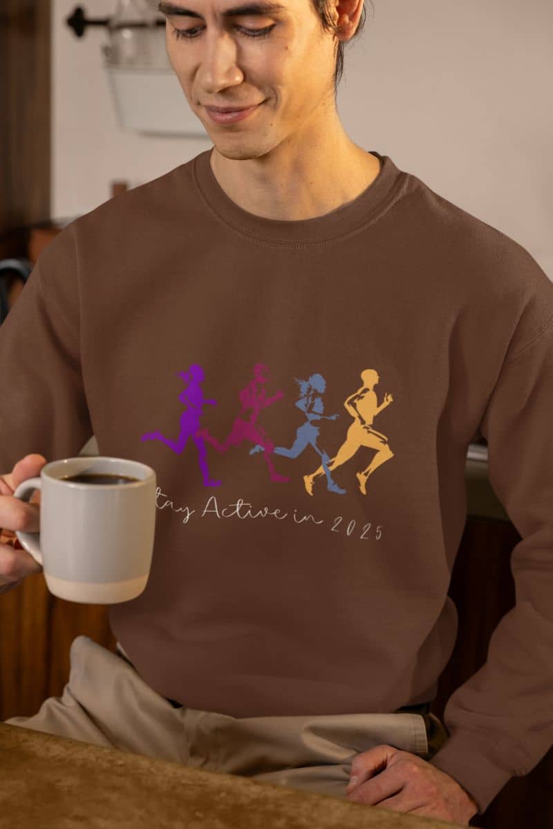 Stay Active in 2025 Sweatshirt with a guy smiling while looking at the cup of coffee in his hand