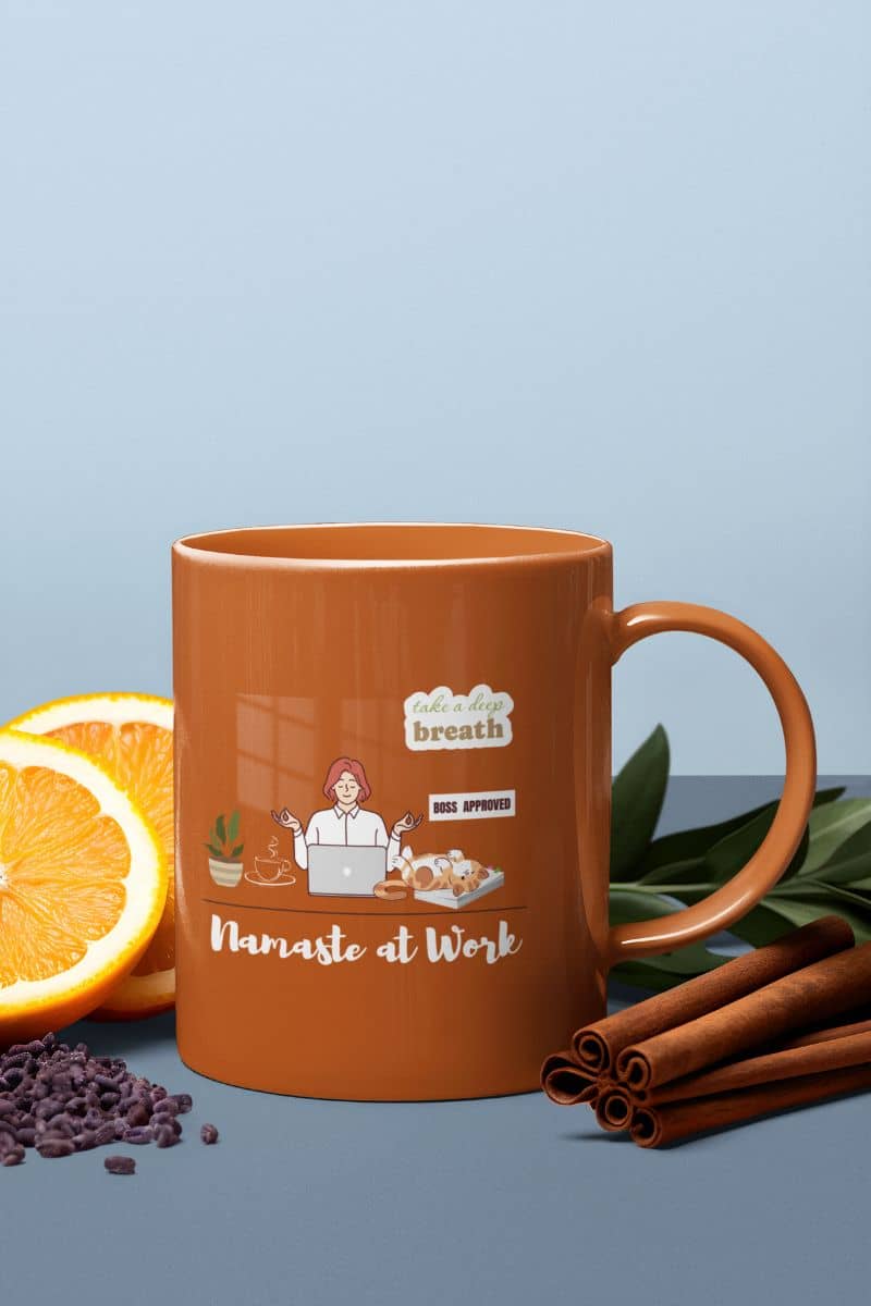 Stress relief coffee mug with an orange cup lying next to a halved orange, green leaves and a few other ingredients