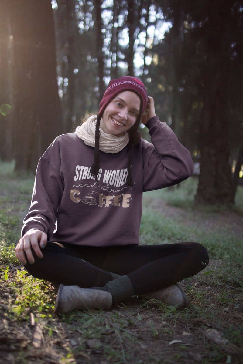 Strong women need strong coffee sweatshirt with a beautiful girl sitting and posing in the forest