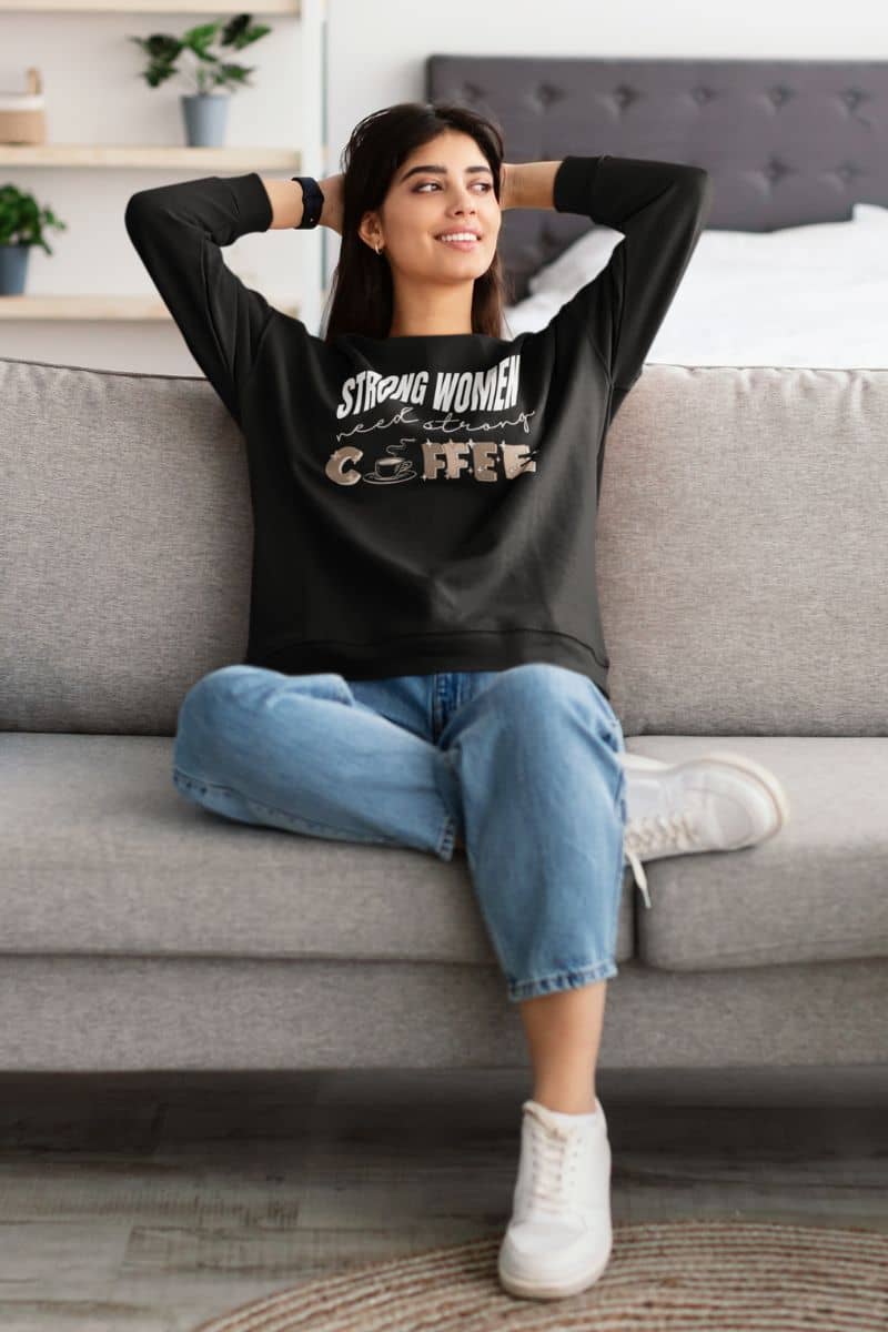 Strong women need strong coffee sweatshirt with a beautiful girl sitting relaxing on the sofa