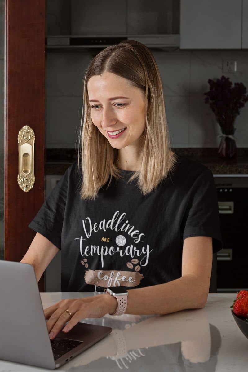 Trendy caffeine lover t-shirt with a woman sitting working in the kitchen