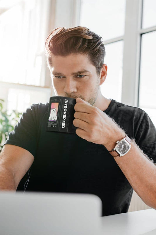 Unique introverted coffee mug with a man working at home while holding a cup of water and looking at a laptop screen