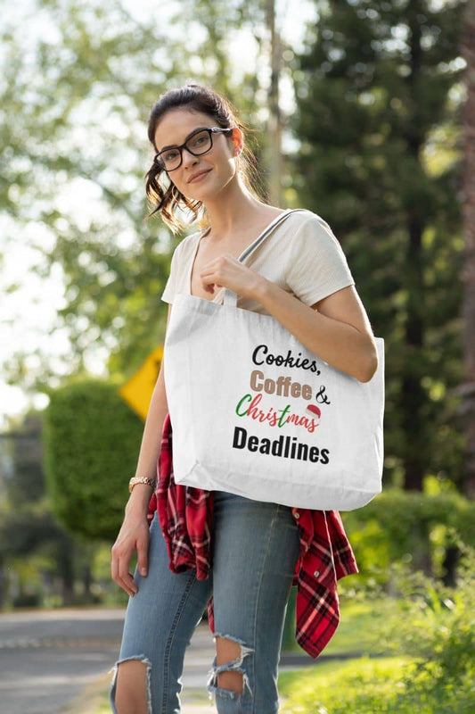Work Christmas tote bag with a woman holding a tote bag with text 'Cookies, Coffee & Christmas Deadlines' outdoors