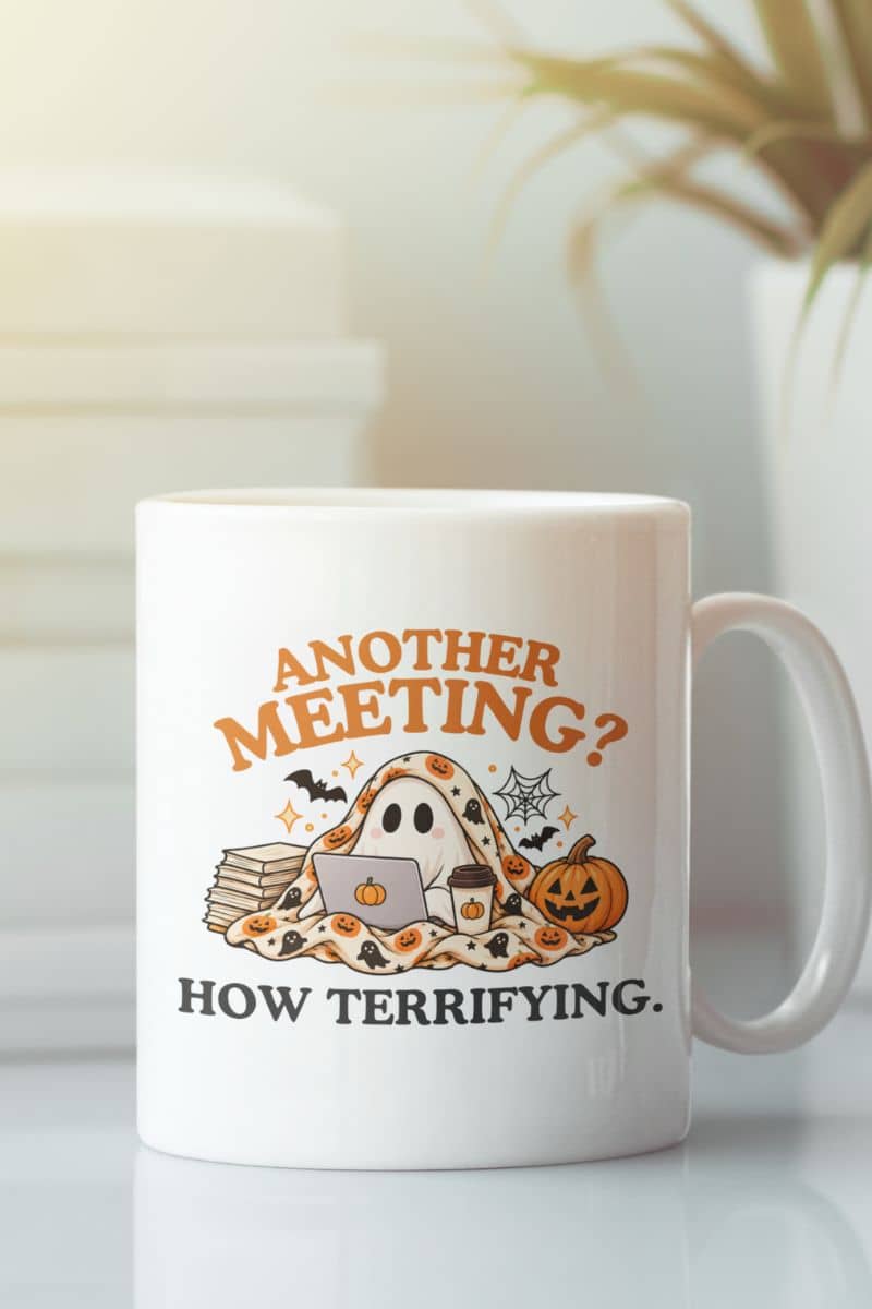A work coffee mug with a Halloween-themed graphic that reads 'Another Meeting? How Terrifying.' with a ghost and a cup of coffee