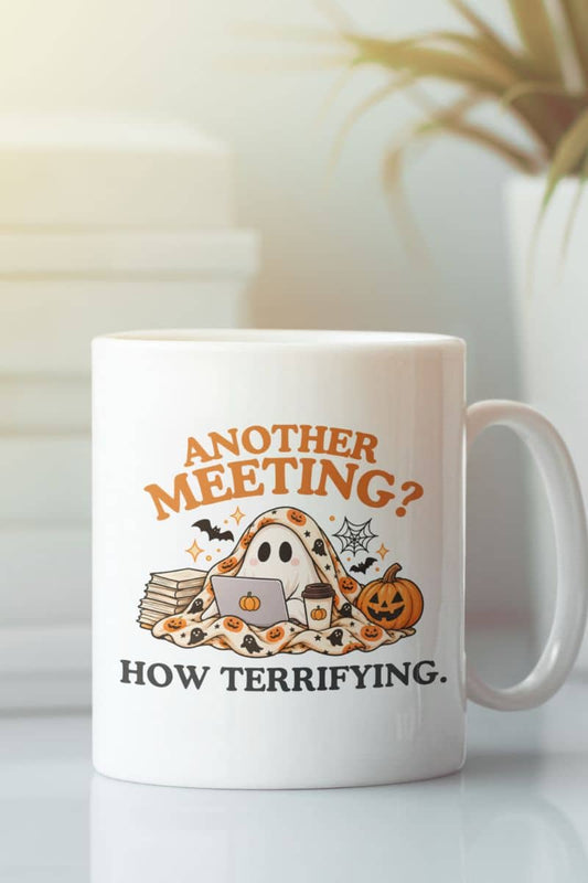 A work coffee mug with a Halloween-themed graphic that reads 'Another Meeting? How Terrifying.' with a ghost and a cup of coffee