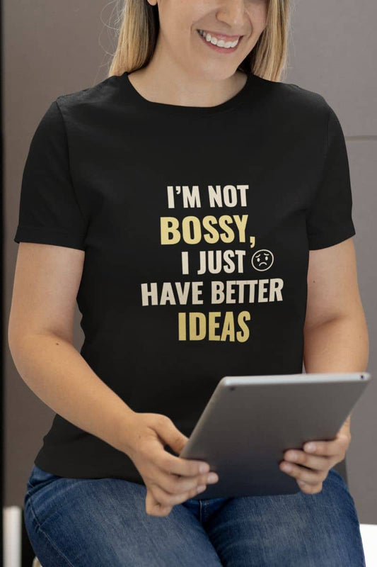 Work humor shirt with a person wearing a black t-shirt with humorous text 'I’m Not Bossy, I Just Have Better Ideas', holding a tablet.