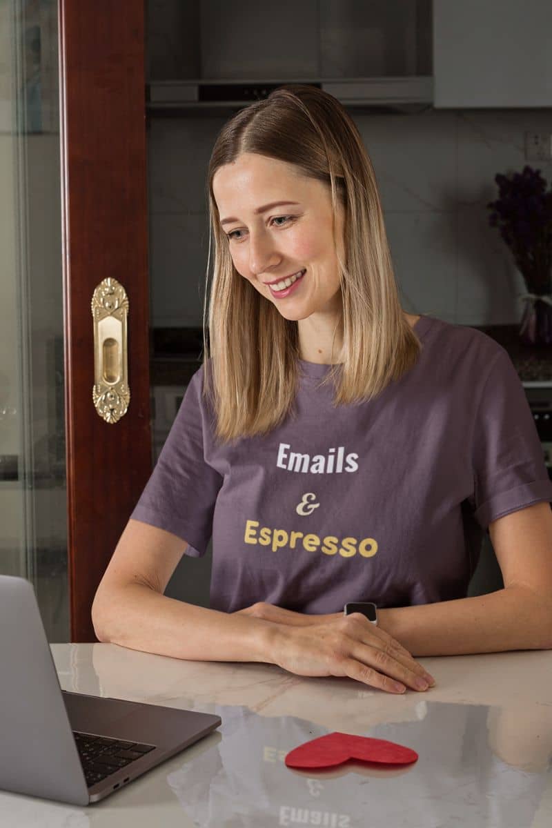 Workday graphic tee with a woman sitting at a kitchen counter with a laptop, wearing a purple t-shirt with text.