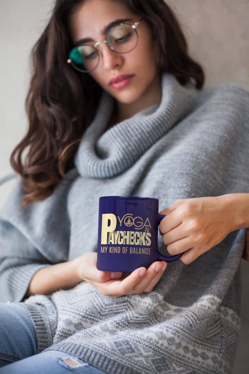 Yoga and paychecks mug with a beautiful girl looking at a cup of coffee held in front of her chest