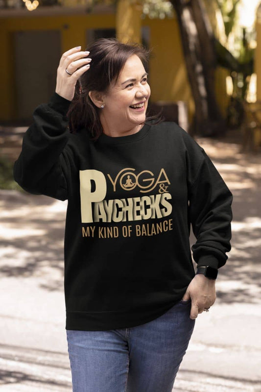 Yoga and paychecks sweatshirt with a middle-aged woman walking down the street with a happy smile looking in one direction