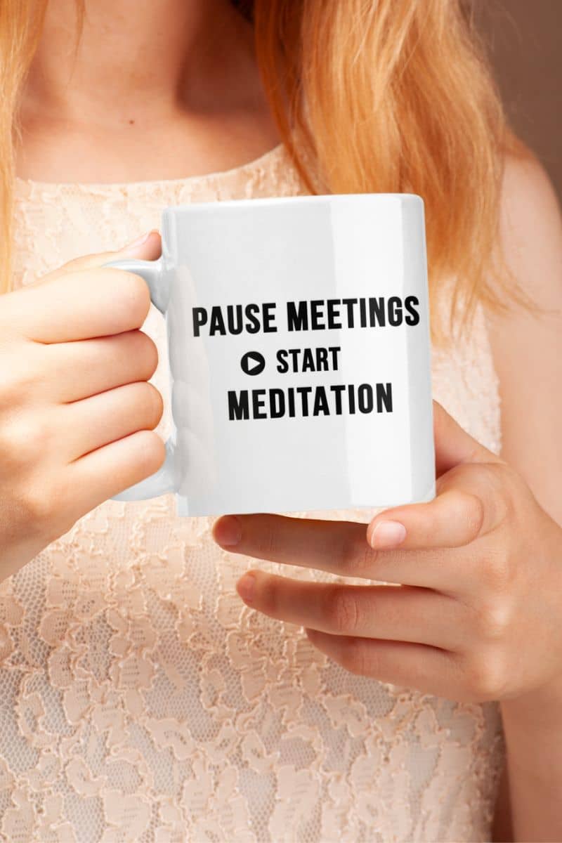 Zen coffee mug featuring a person holding a mug with text 'Pause Meetings, Start Meditation'