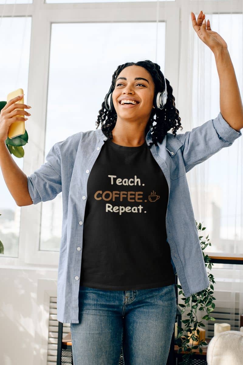 back to school shirt with a woman wearing a black graphic t-shirt with text 'Teach. Coffee. Repeat.'