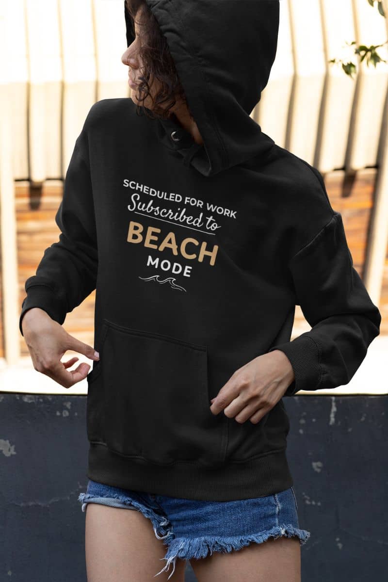 beach hoodie with a person wearing a black hoodie with text 'Scheduled for work, Subscribed to Beach Mode' outdoors.