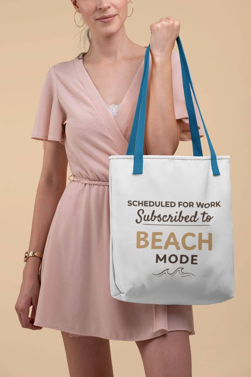 beach tote bag with a woman holding a tote bag with text 'Scheduled for work, Subscribed to Beach Mode' against a beige background