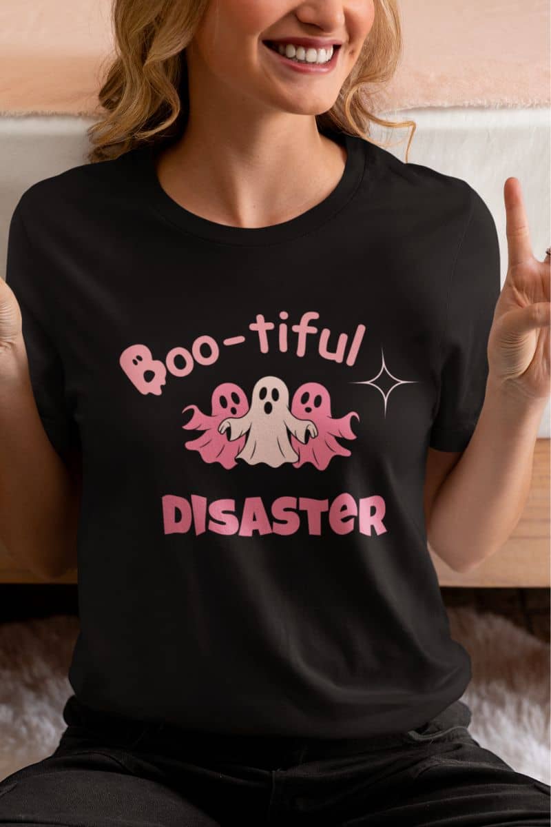 boo crew t-shirt with a person wearing a black t-shirt with 'Boo-tiful Disaster' design featuring ghosts.
