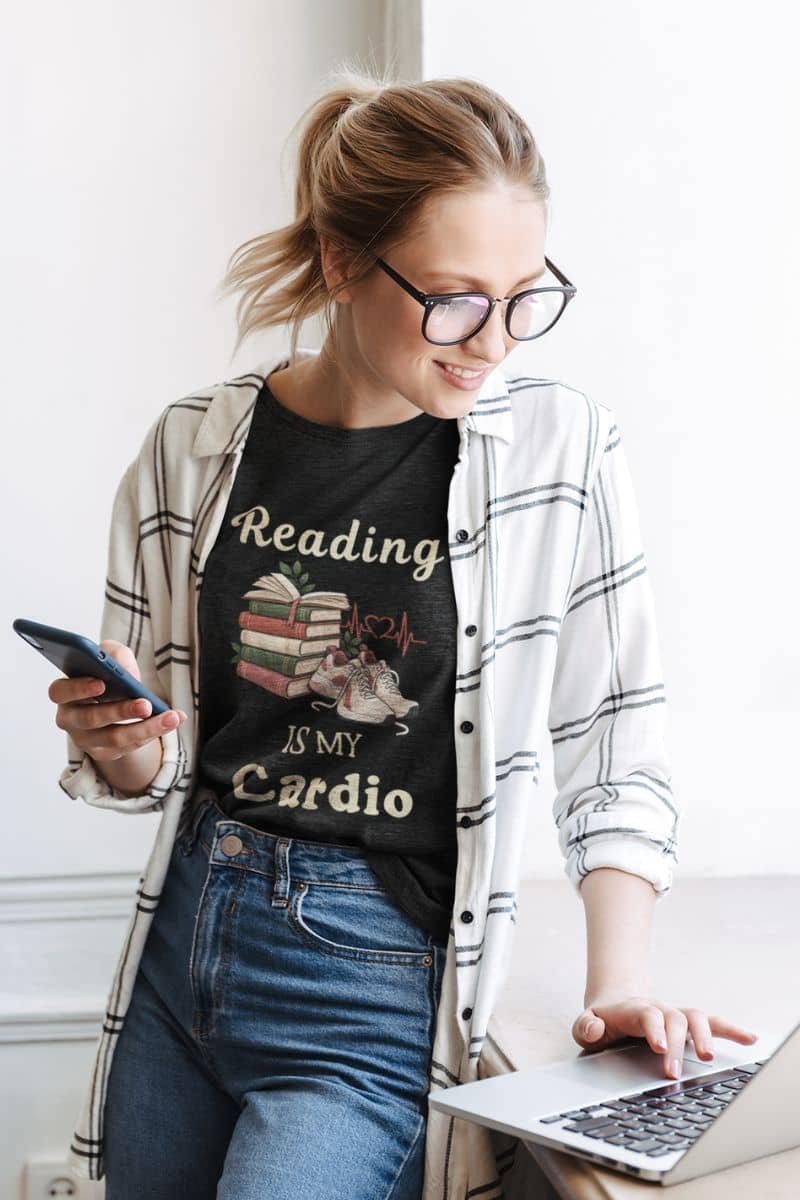 book lover t shirt with a woman wearing a Reading is my Cardio design, looking at the laptop