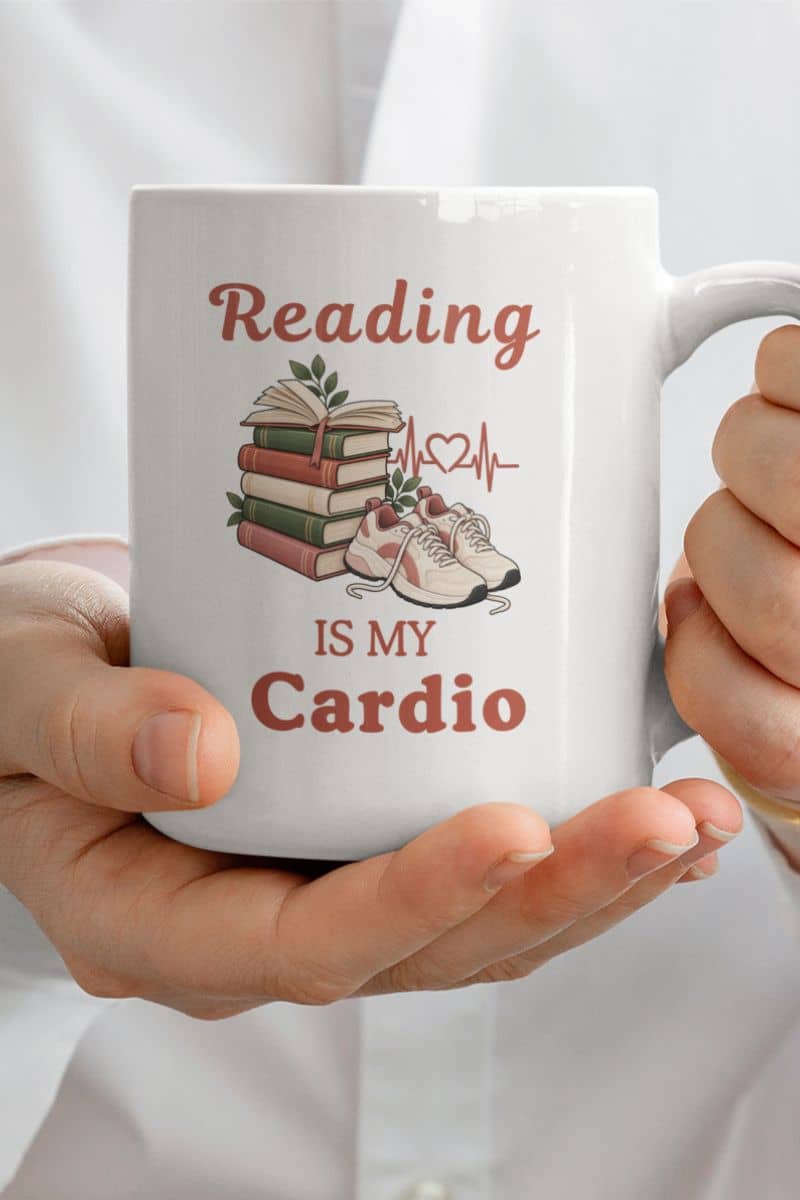 bookworm mug with a person holding a white ceramic mug that reads 'Reading IS MY Cardio' 