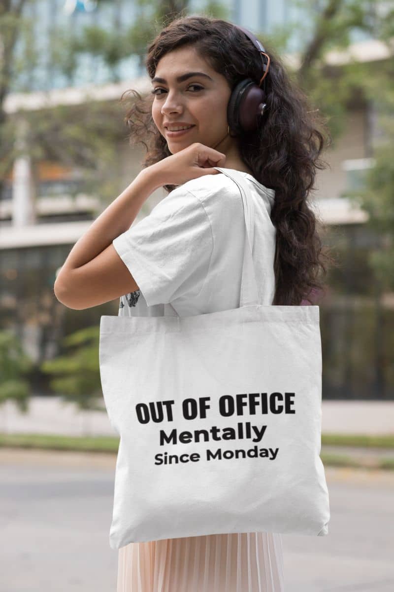 burnout humor tote with a woman carrying a tote bag with text 'Out of Office. Mentally Since Monday.'
