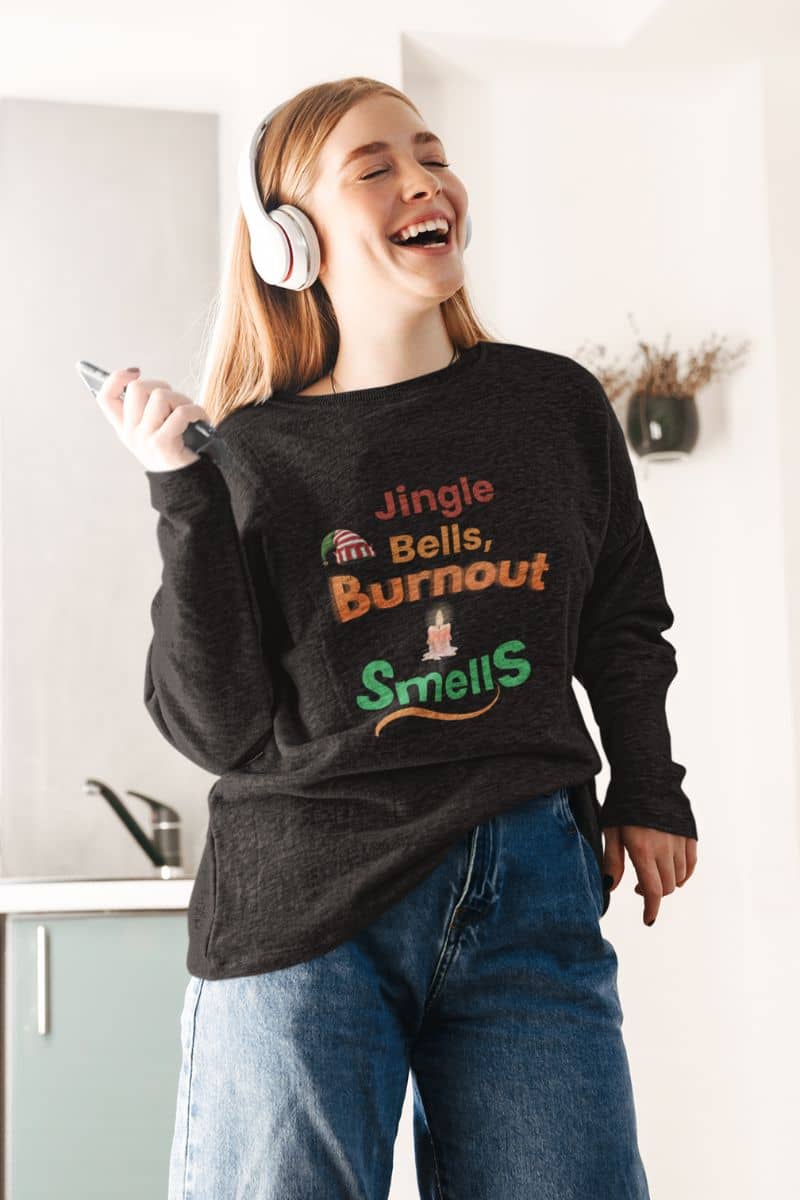 burnout recovery top with a person wearing a dark sweatshirt with humorous text, laughing in a kitchen.