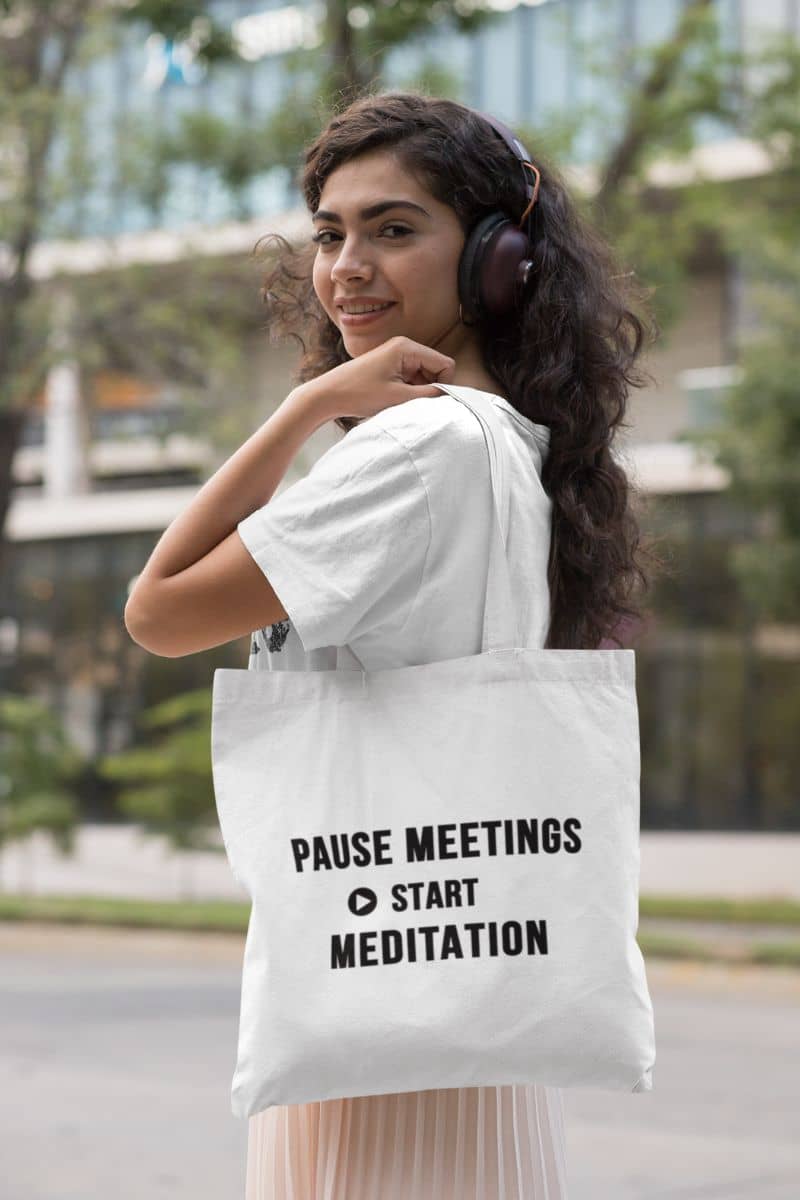 burnout recovery tote with a woman carrying a tote bag featuring the text 'Pause Meetings, Start Meditation'
