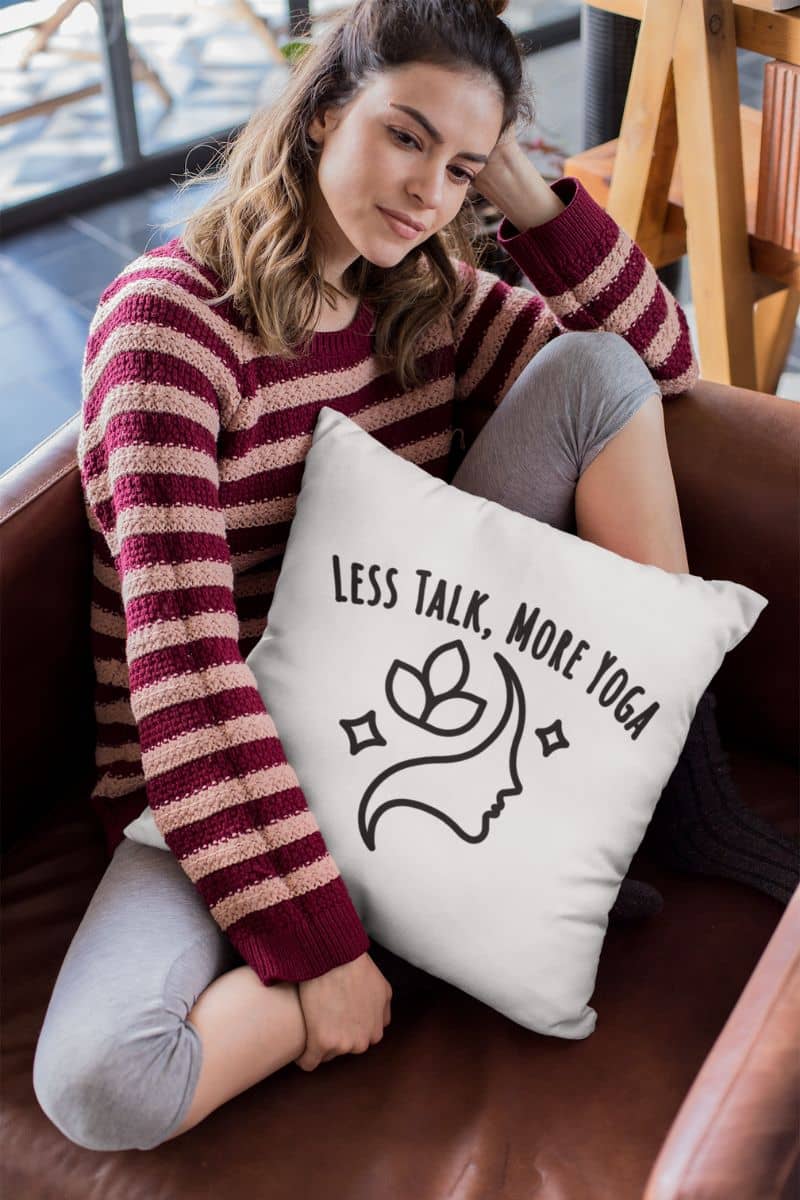 calm living room pillow with a woman sitting on a couch with a pillow that says 'Less Talk, More Yoga' in a casual setting.