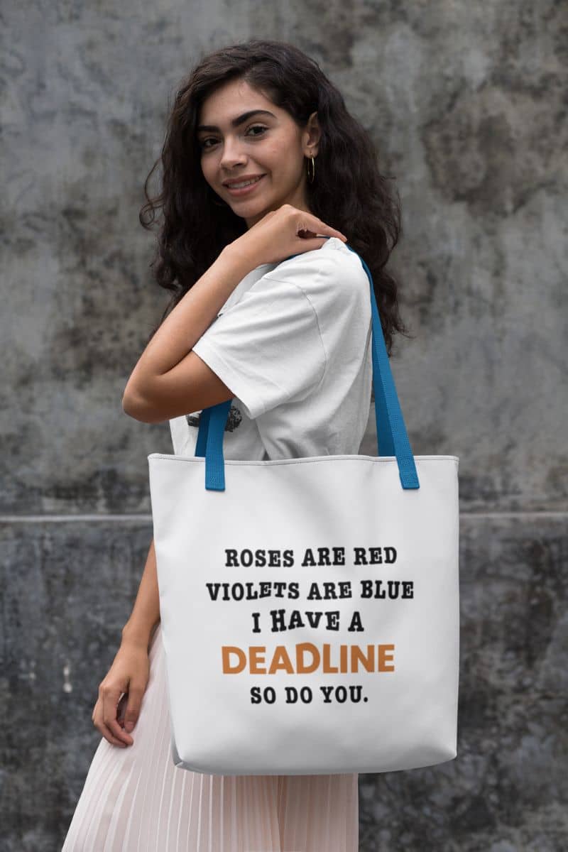 canvas tote for work with a woman holding a tote bag with a humorous quote 'Roes are red, violets are blue. I have a deadline so you do' against a textured wall.