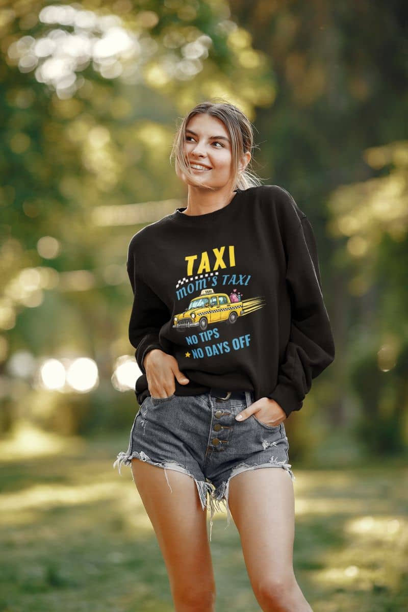 carpool mom sweatshirt with a woman wearing a black sweatshirt with text 'Taxi, Mom’s Taxi – No tips, no days off' in a forest setting
