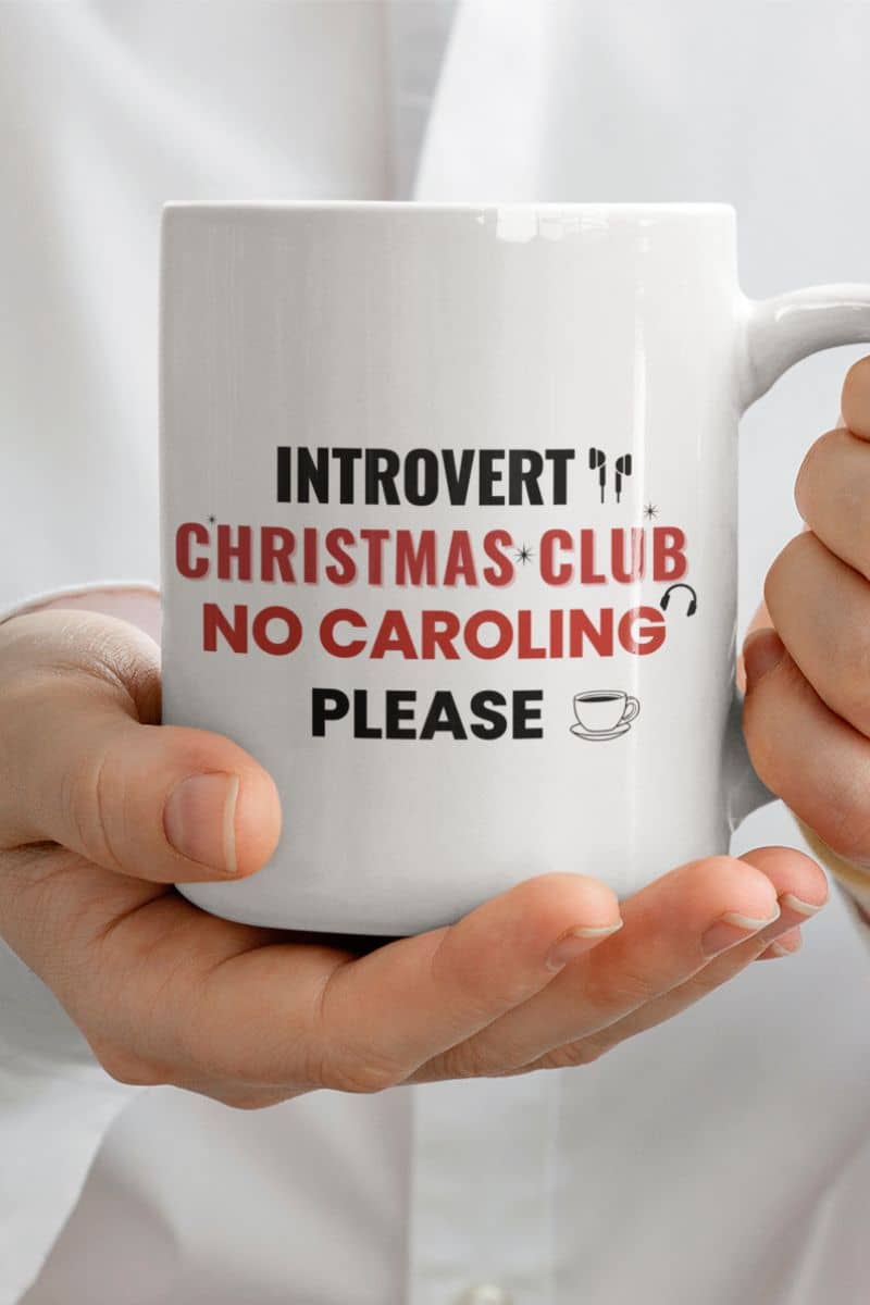 christmas coffee mug with a person holding a mug with text 'Introvert Christmas Club, No Caroling Please'