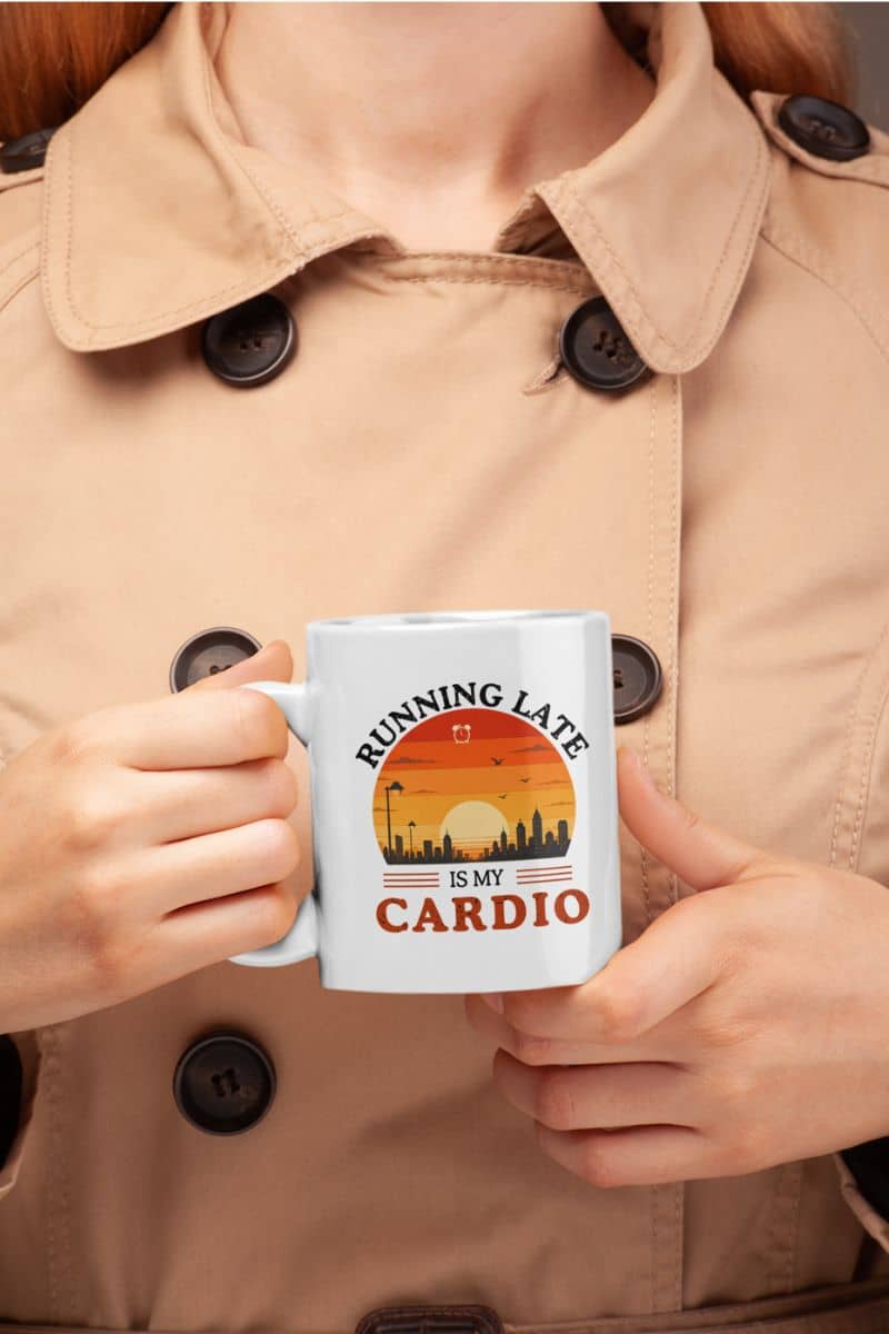 coffee lover mug with a person holding a mug with 'Running late is my cardio' design, wearing a beige coat.