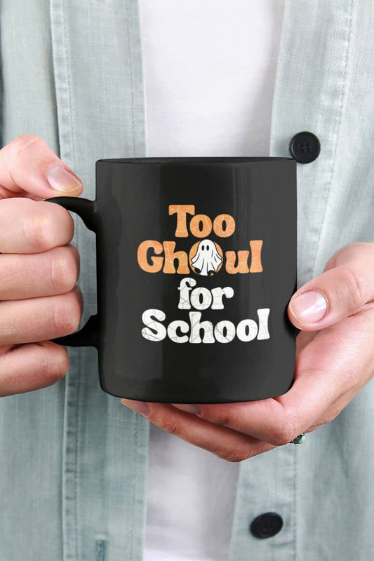coffee mug with a person holding a black mug with 'Too Ghoul for School' text