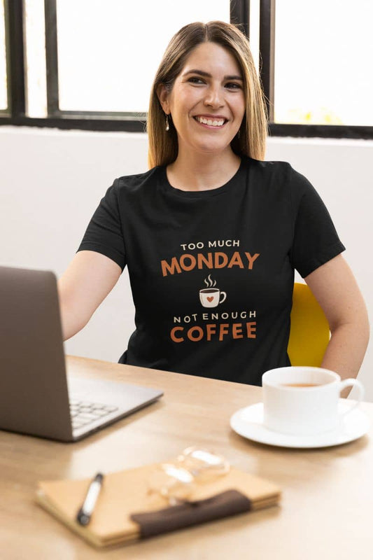 coffee shirt with a woman wearing a t-shirt featuring the text 'Too Much Monday, Not Enough Coffee', sitting at the desk