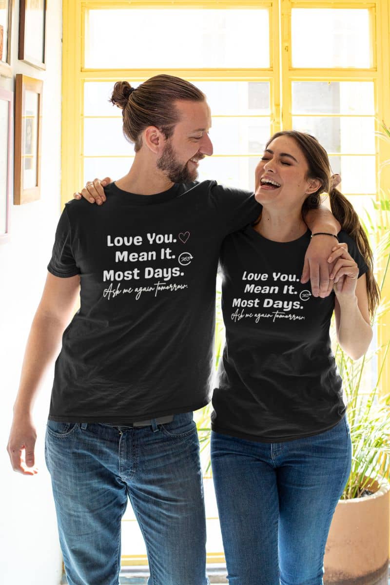 couples humor t-shirt with two people wearing matching black t-shirts with a romantic message, standing close together.