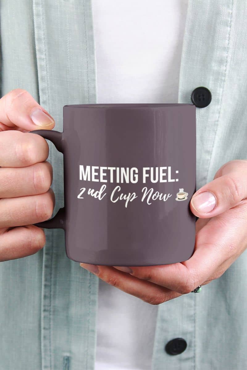 coworker gift coffee cup with a person holding a mug with 'Meeting Fuel: 2nd Cup Now' text