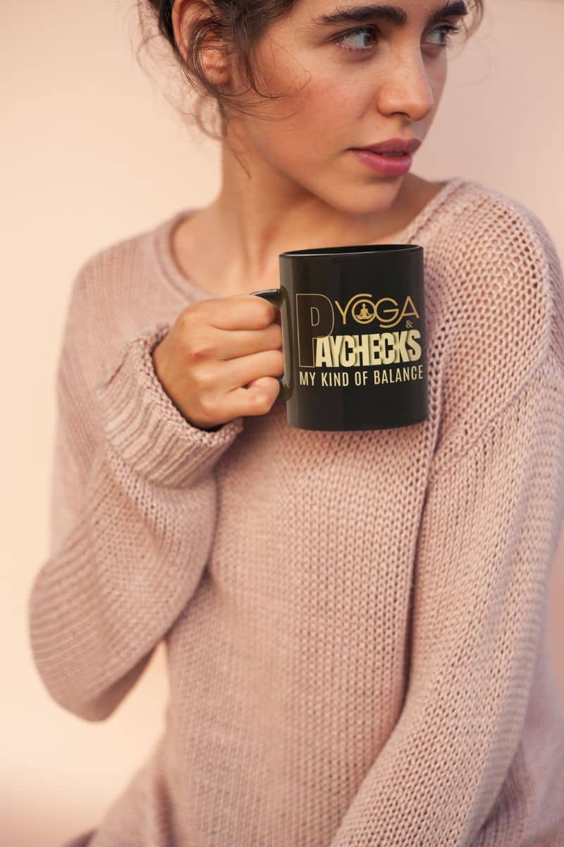 cozy desk mug with a woman holding a black mug with text, wearing a pink sweater against a plain background
