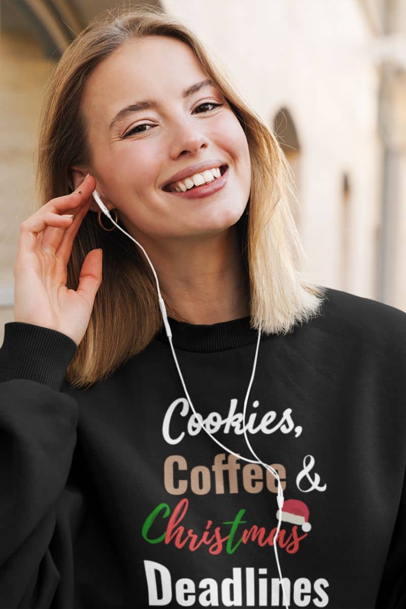 cozy holiday pullover with a woman wearing a black sweatshirt with 'Cookies, Coffee & Christmas Deadlines' text.